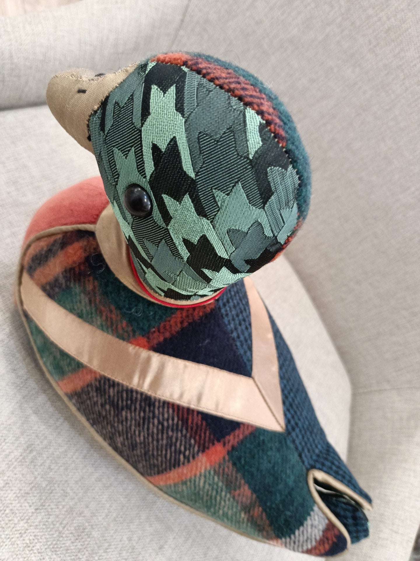 Pato decorativo em tecidos coloridos com padrões pied-de-poule e xadrez