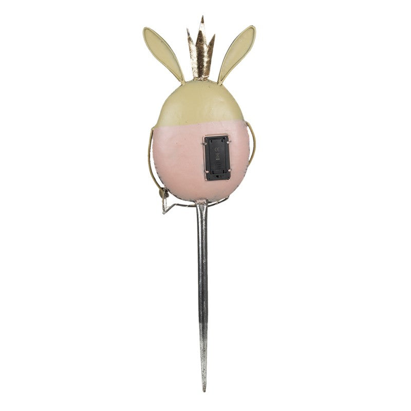 Produto decorativo em forma de ovo com orelhas, coroas douradas, suporte metálico e compartimento para pilhas