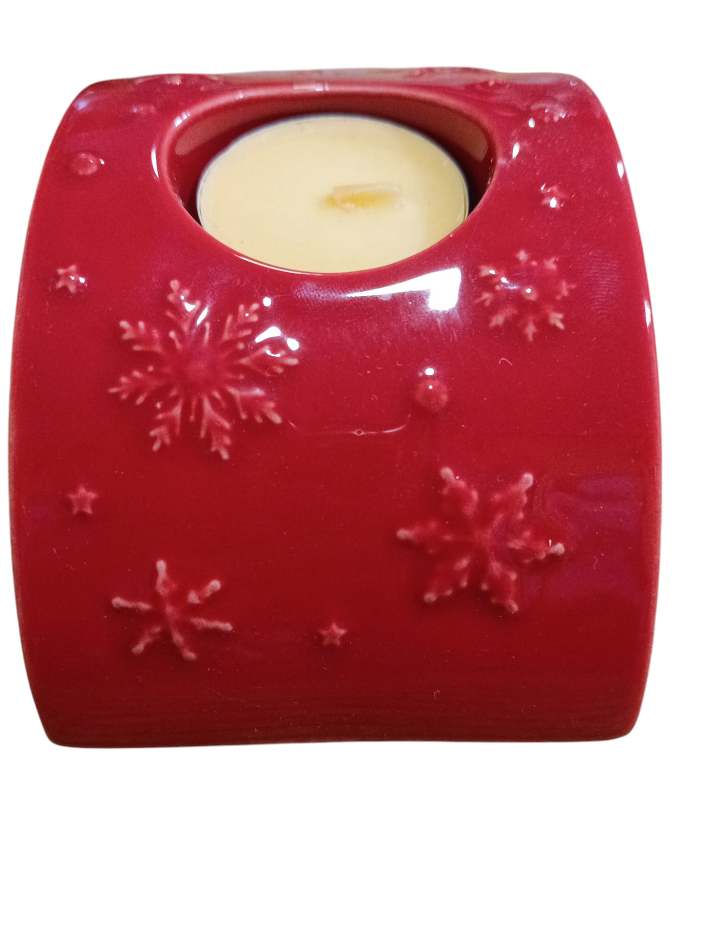 Suporte vermelho para vela com flocos de neve em relevo e vela creme inserida.