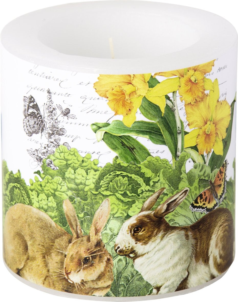 Vela decorativa com ilustrações de coelhos, flores amarelas e borboletas