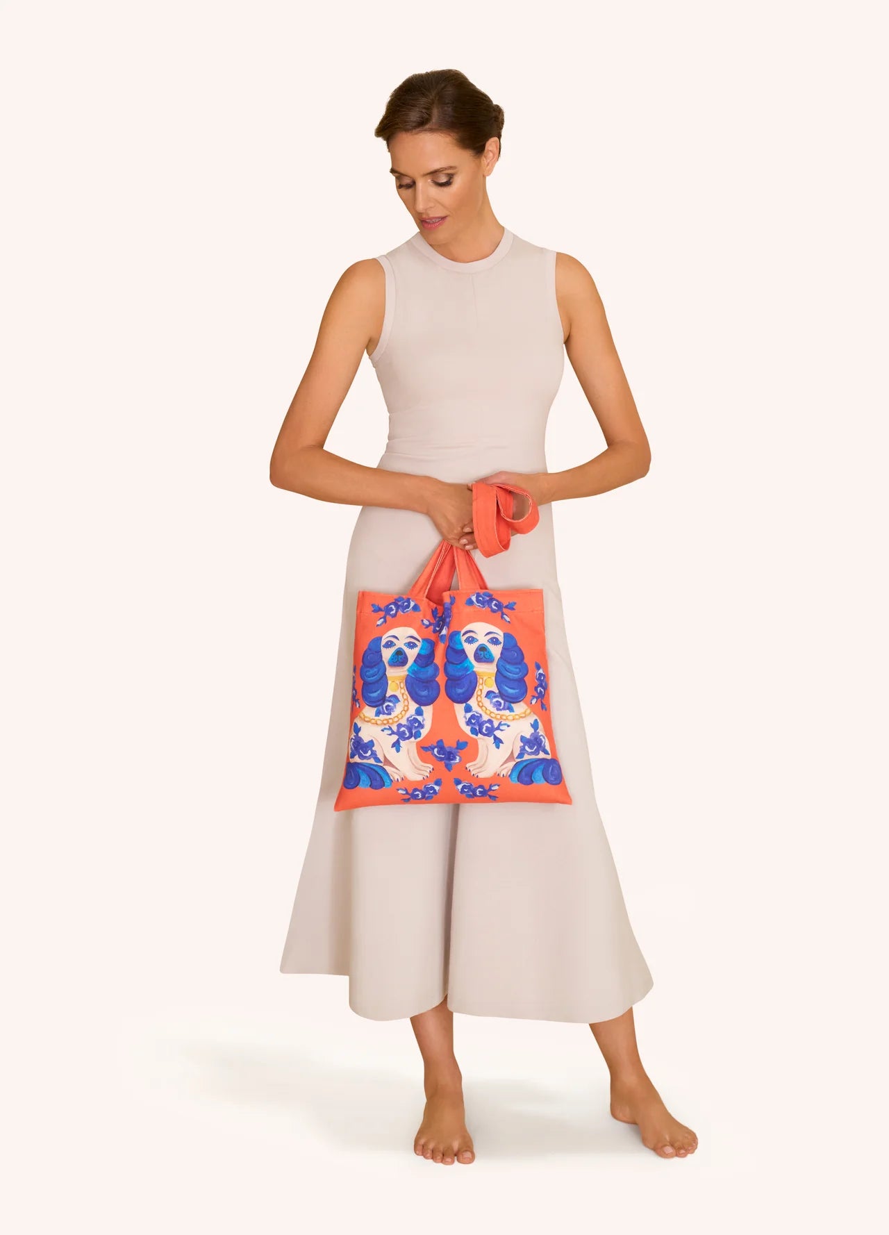 Mulher segurando bolsa de tecido coral com padrão azul e branco