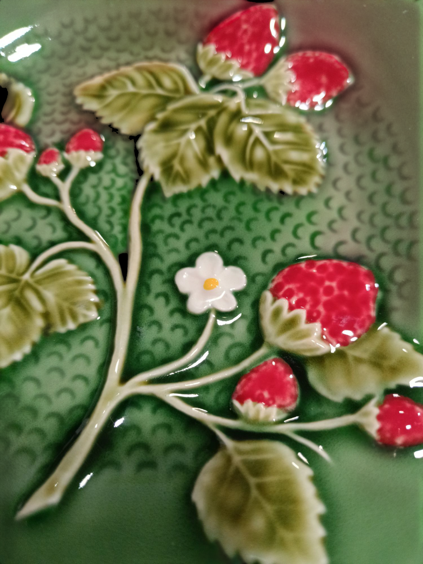 Placa decorativa em cerâmica com desenhos de morangos e folhas em relevo