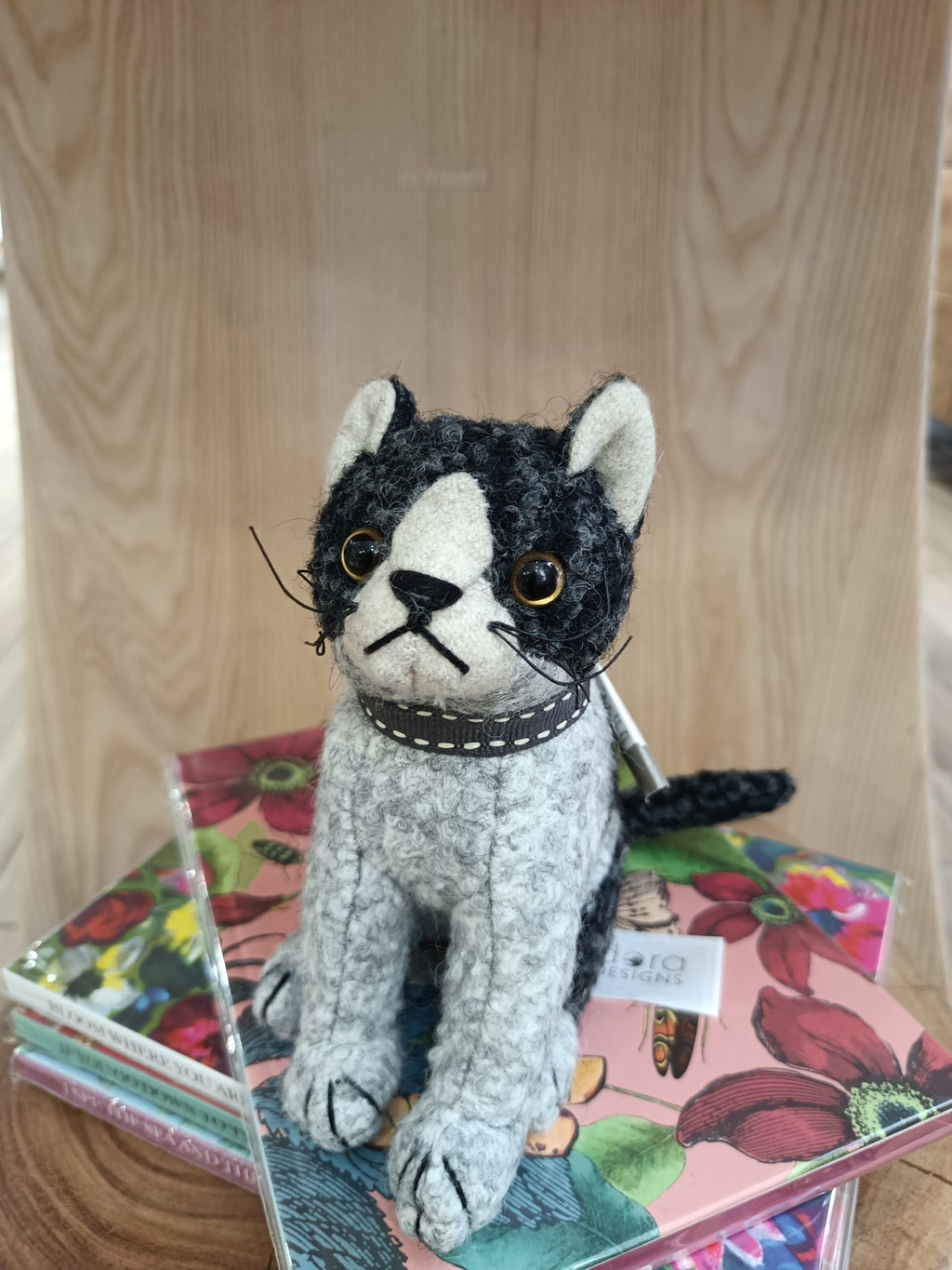 Pelúcia de gato preta e cinzenta com olhos castanhos