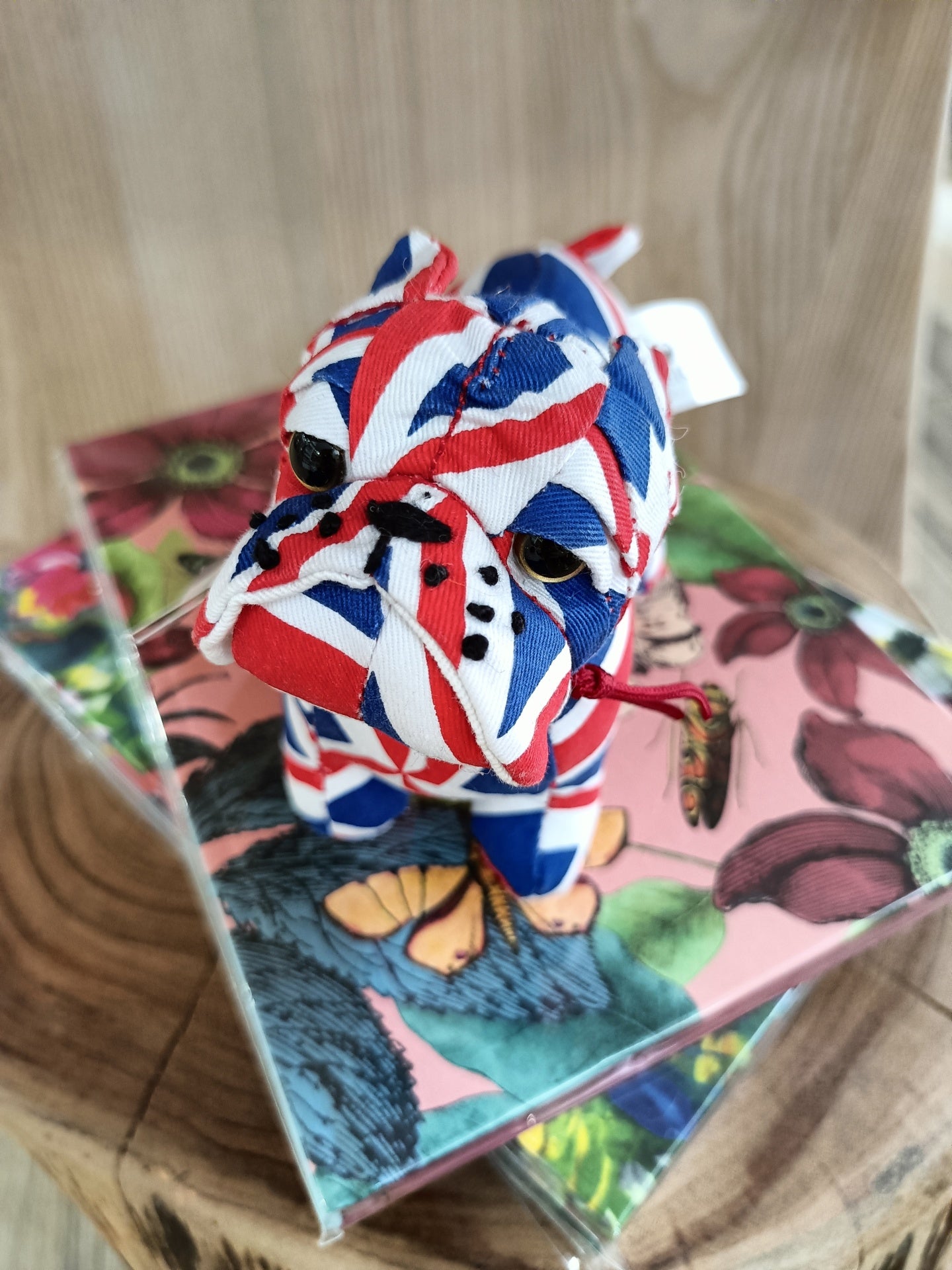 Boneco de bulldog em tecido com padrão da bandeira do Reino Unido sobre caixas com padrões florais