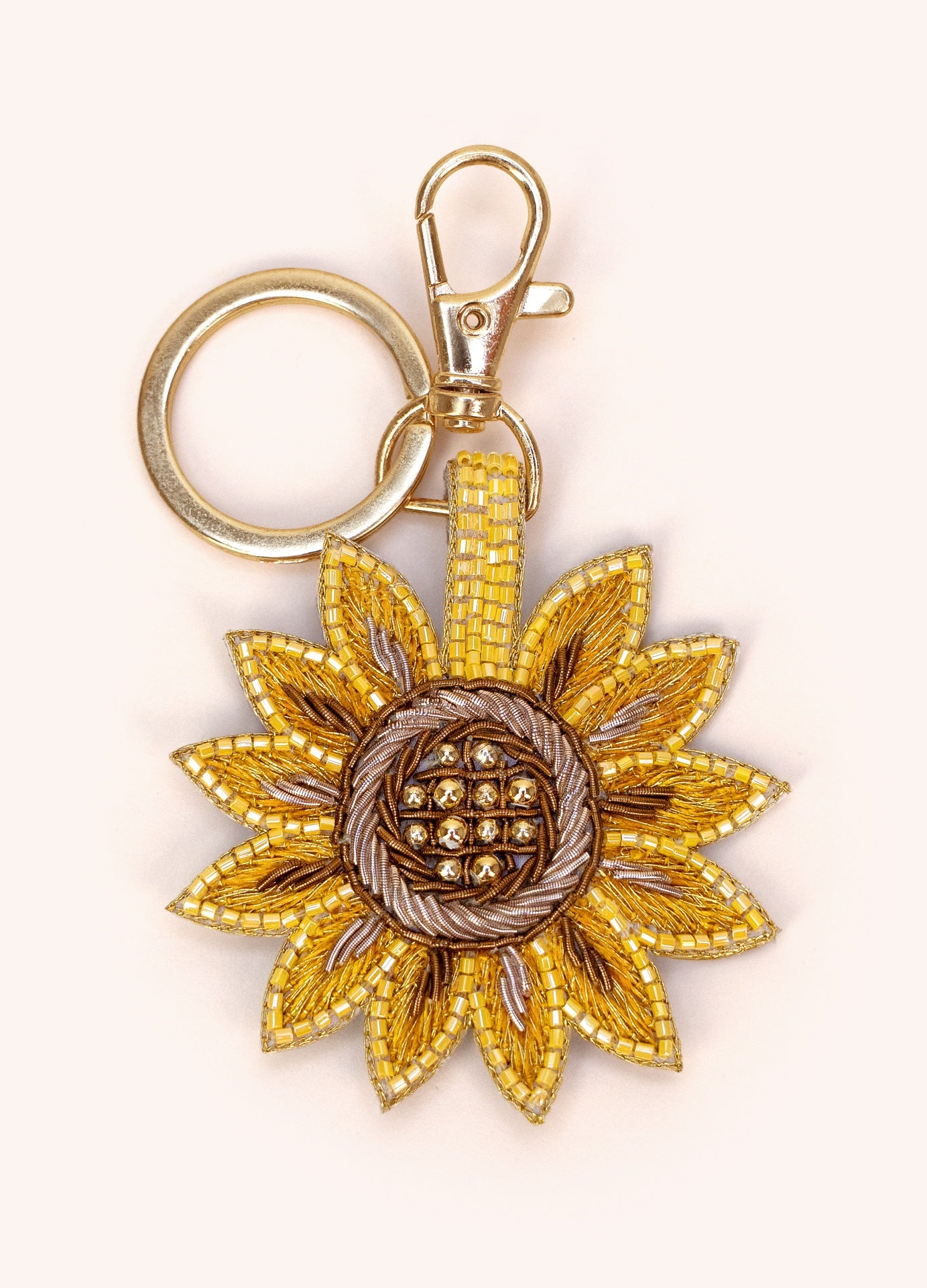 Chaveiro dourado com pendente de girassol em contas e tecido