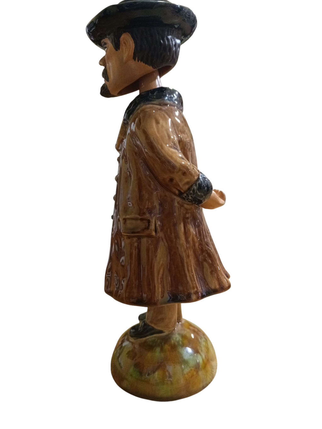 Estátua decorativa de homem com casaco castanho e chapéu preto, vista lateral
