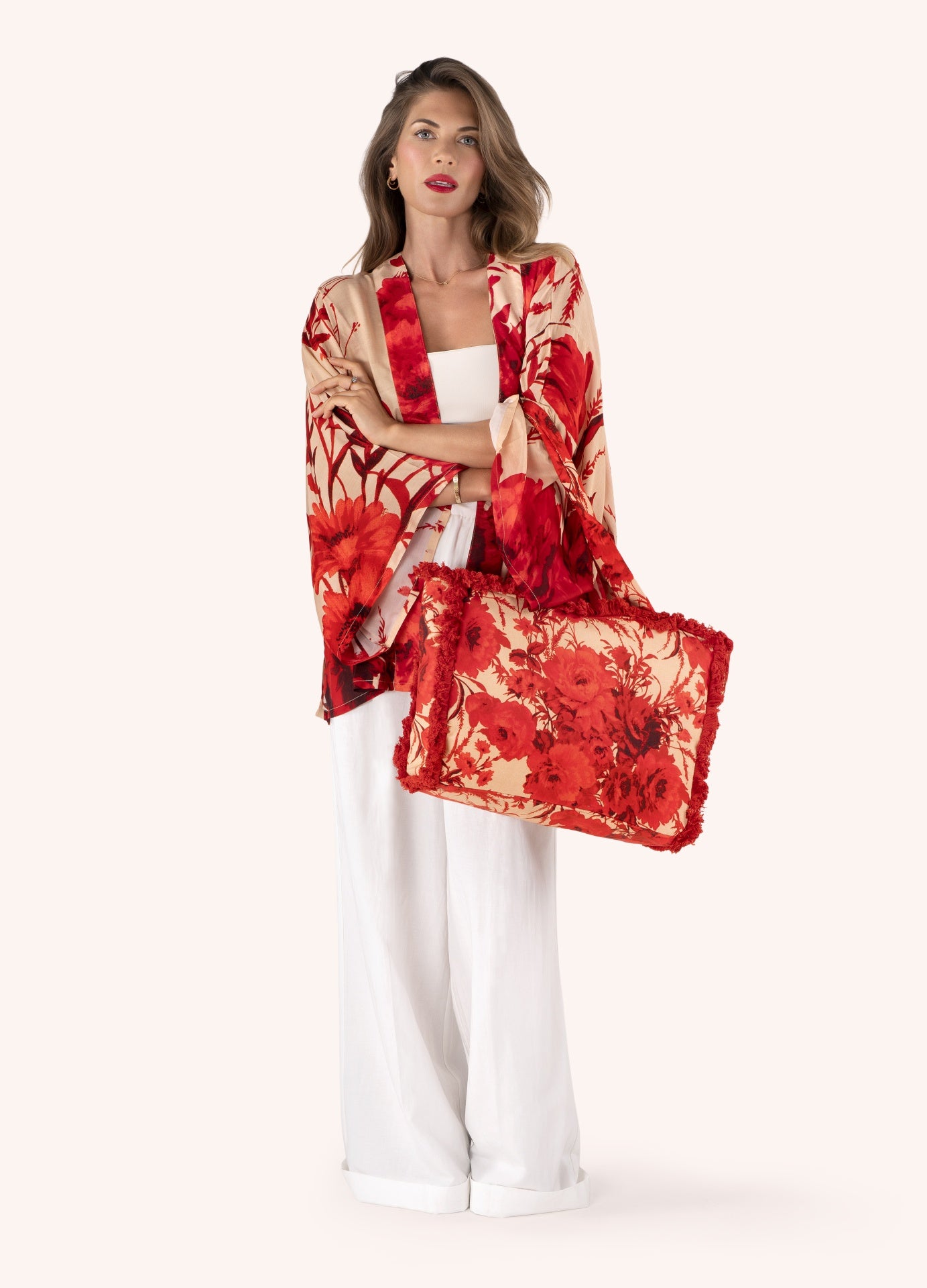 Mulher com roupa branca e xale com padrão floral vermelho a combinar com bolsa floral