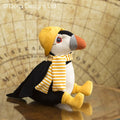 Pelúcia papagaio-do-mar com cachecol e gorro amarelo