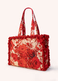 Bolsa de tecido floral vermelho com franjas vermelhas nas bordas