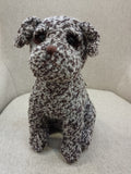 Boneco peluche cão tecido cru castanho em cadeira cinza