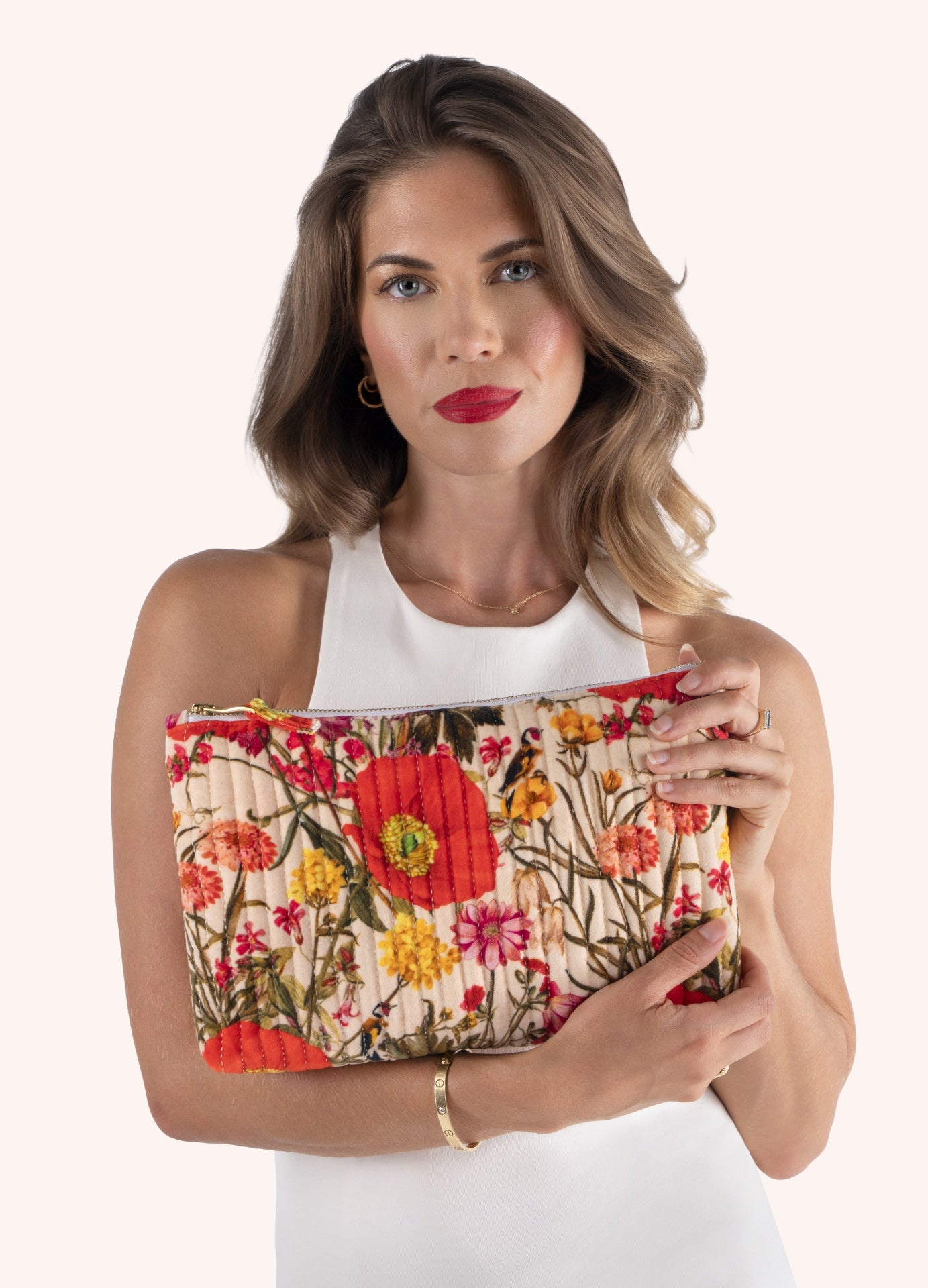 Carteira acolchoada floral colorida, mulher a segurá-la com vestido branco