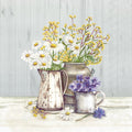 Três jarros com flores de cores diferentes sobre mesa clara e fundo cinza