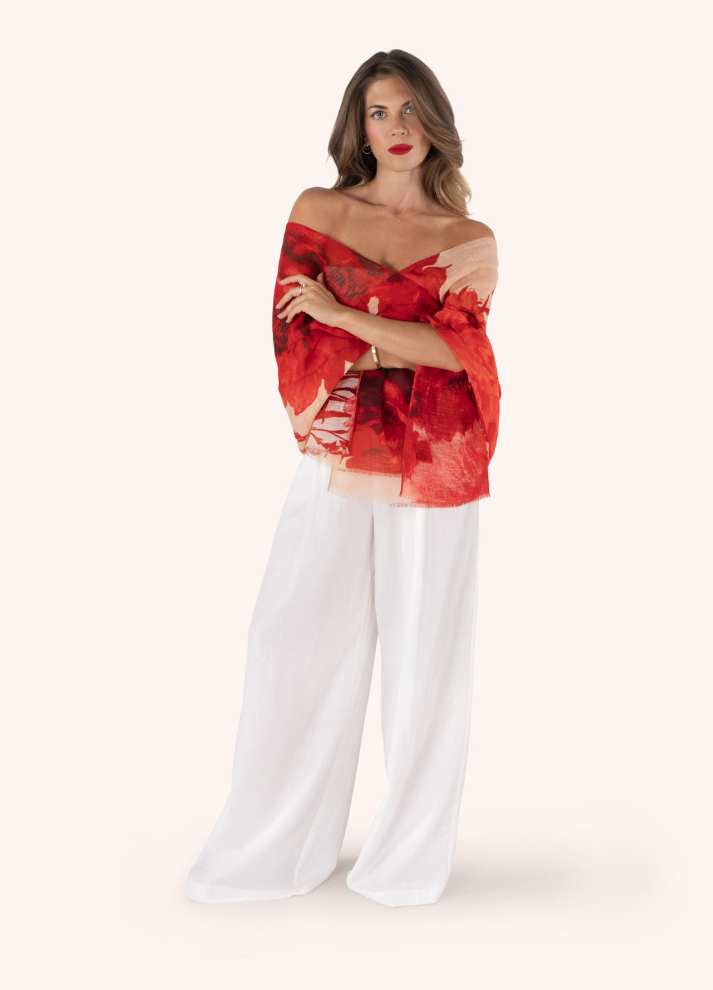 Mulher com lenço ou xale vermelho com padrão abstracto e calças largas brancas