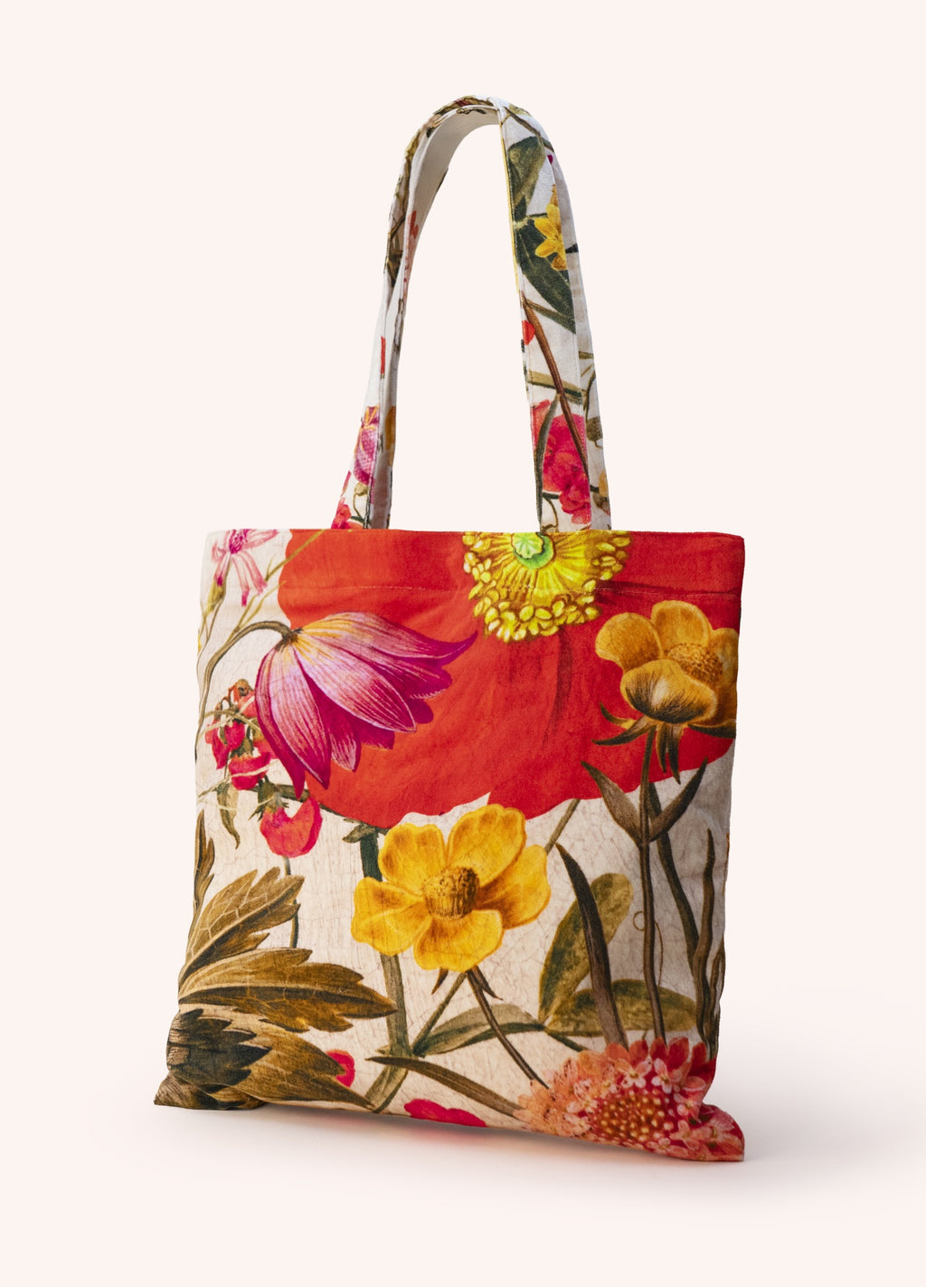 Saco de tecido com estampado floral colorido e pegas iguais ao padrão.