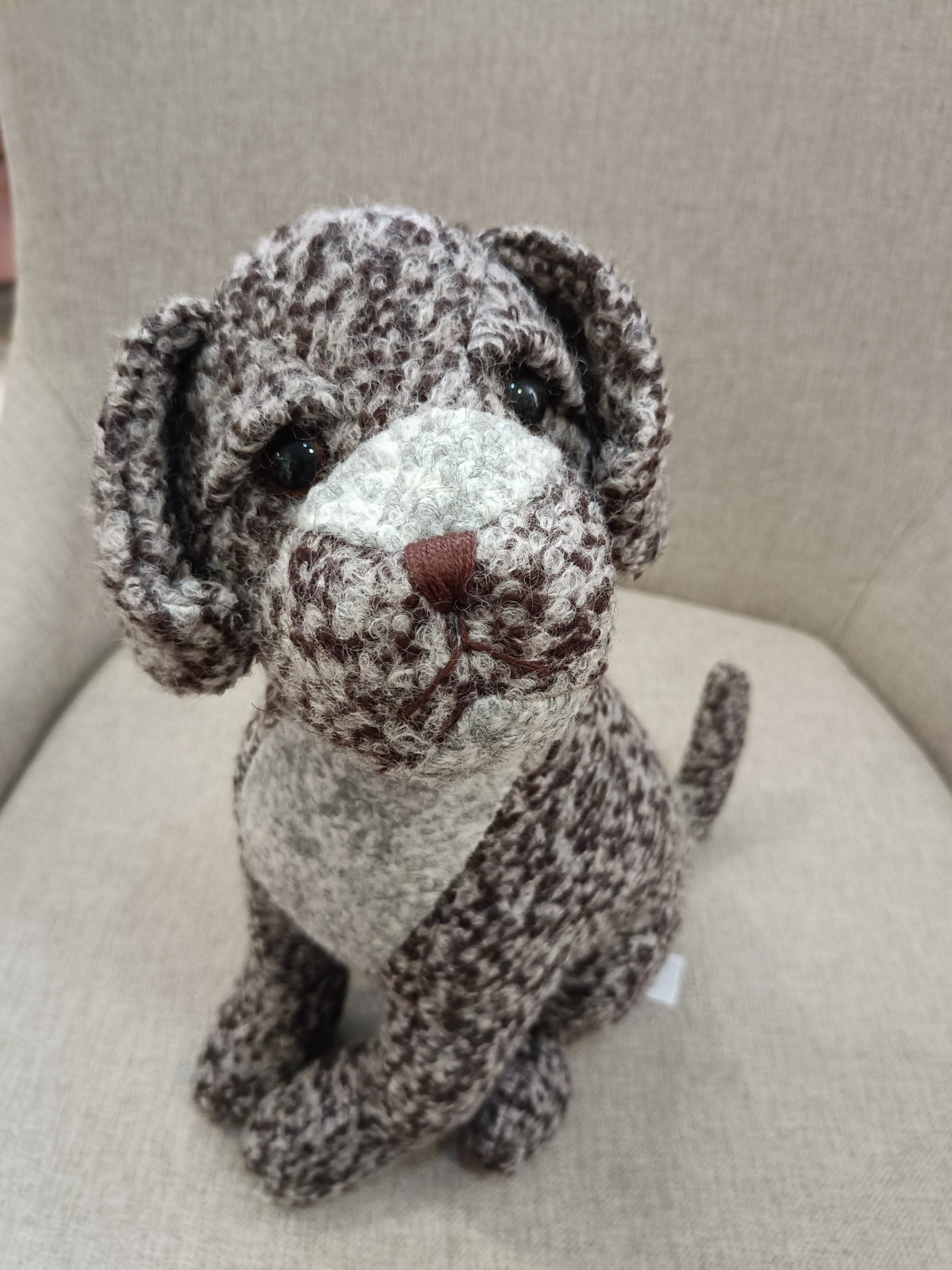 Pelúcia de cão castanho e branco sentada
