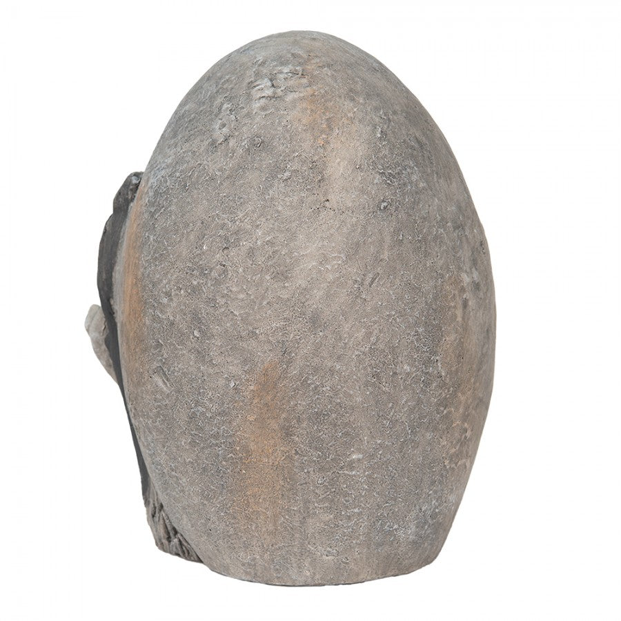 Escultura cinzenta ovalada com textura rugosa sobre fundo branco